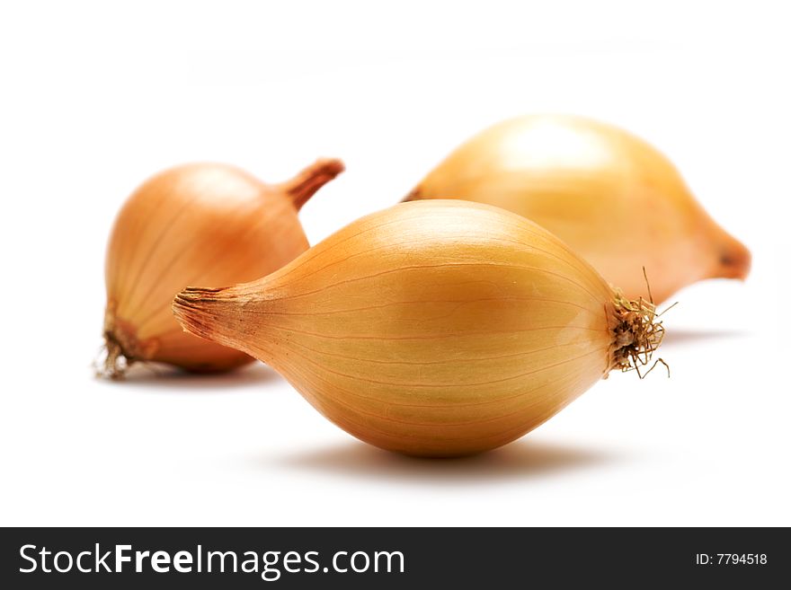 Three onions are on a white background. Background blurred. Isolated.