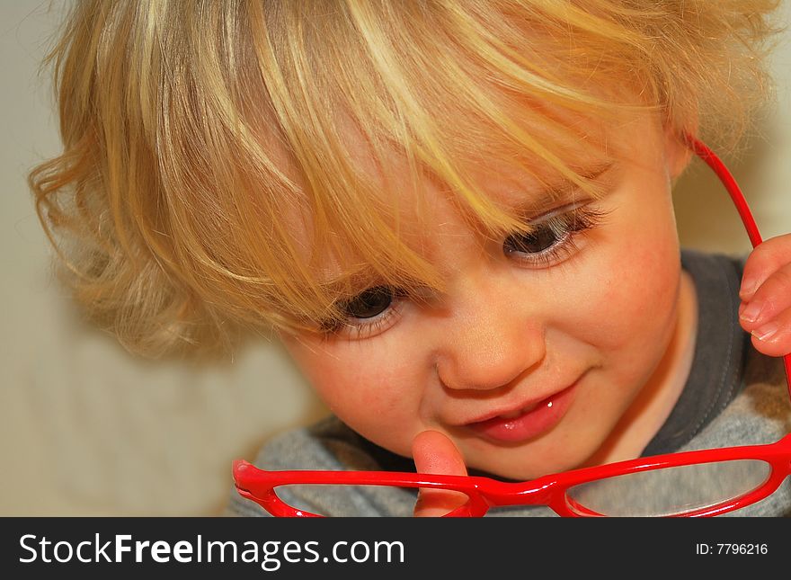 Toddler checking out red eyeglasses