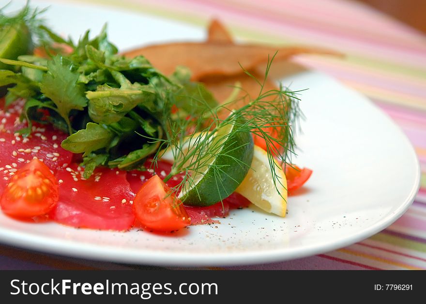 Crude tuna with leaves of salad and vegetables