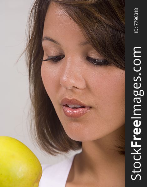 A beautiful young Asian-American girl eats an apple