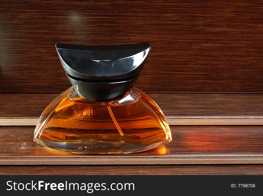 Bottle of perfume on a wooden background