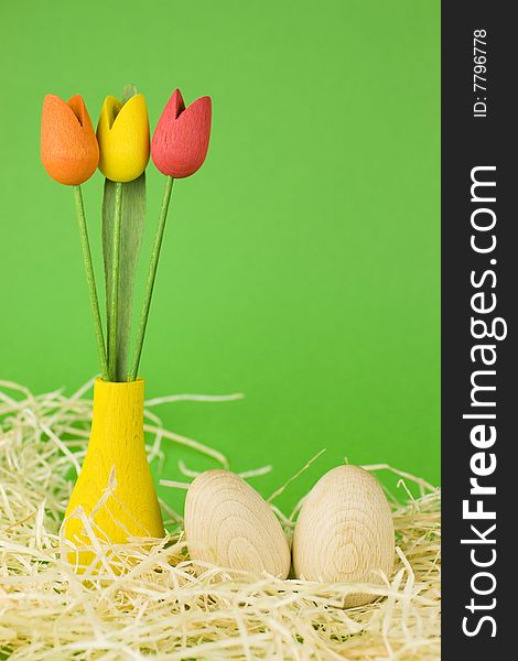 Wooden easter eggs with red, yellow and orange wooden tulips decoration.