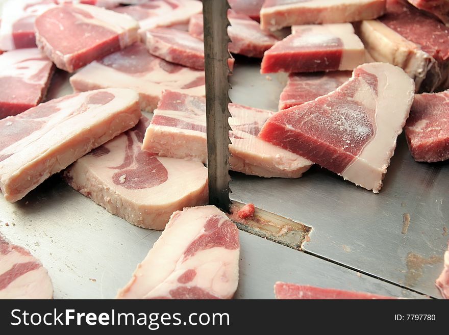 Cut of meats in butcher on saw machine