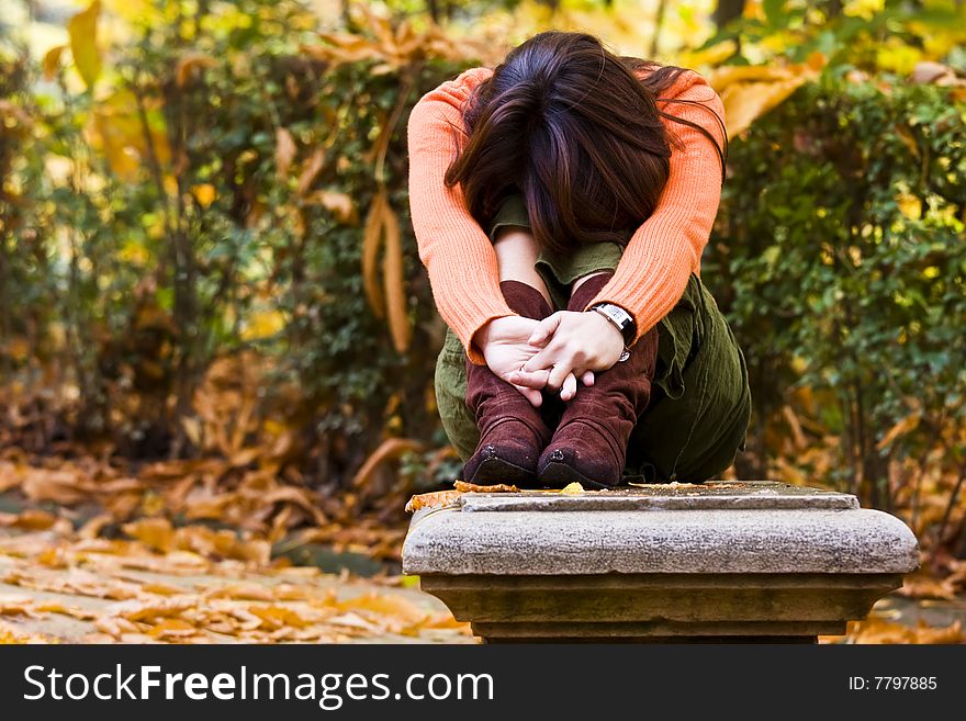 Young woman sitting between autumn colors. Young woman sitting between autumn colors.