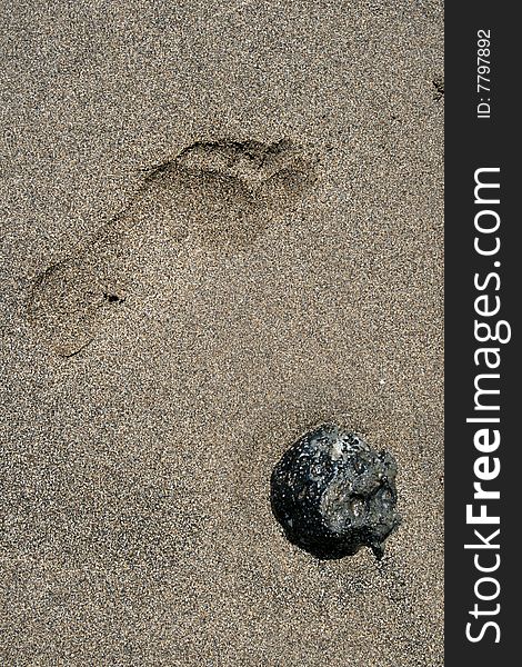 Print of feet in the sand and a stone. Print of feet in the sand and a stone