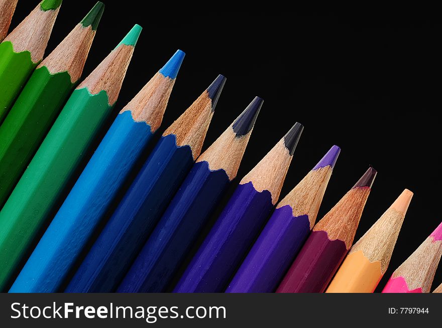 Thick colored pencils against a black background