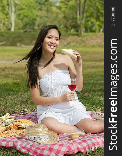 Woman eating a sandwich and drinking wine. Woman eating a sandwich and drinking wine