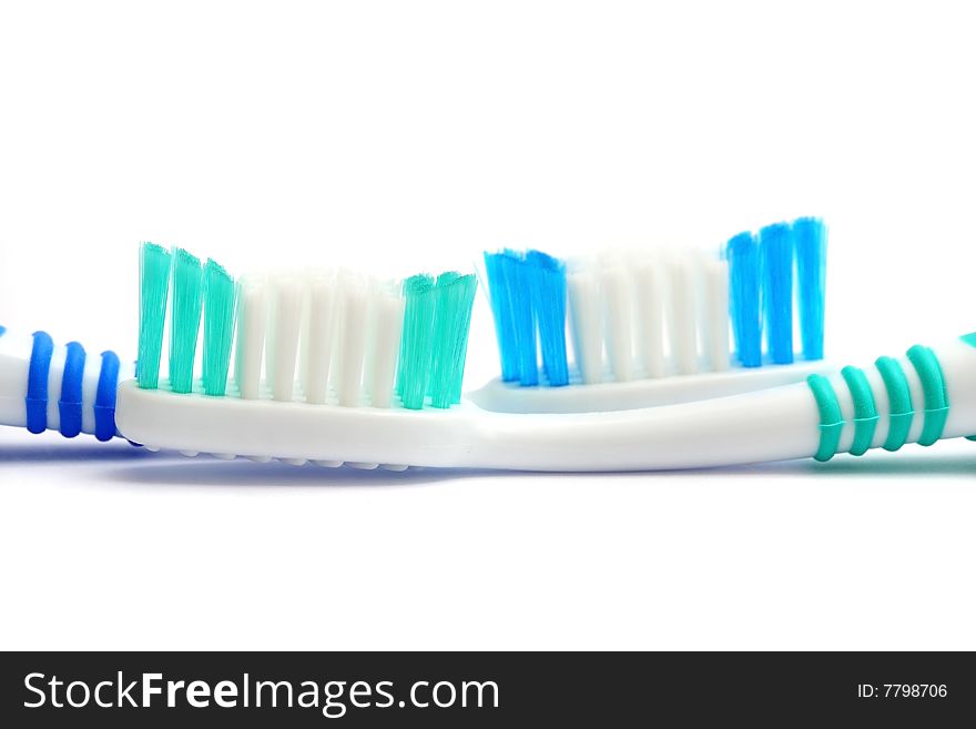 Close up of two tooth brushes on white background.