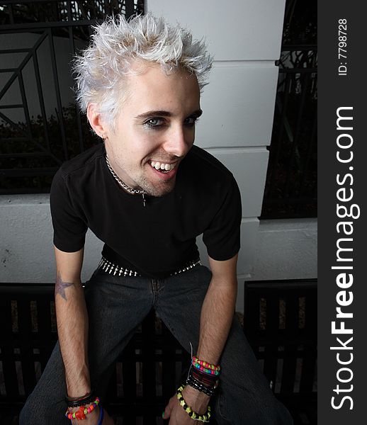 Young man with bleached hair looking upward with a smile. Young man with bleached hair looking upward with a smile