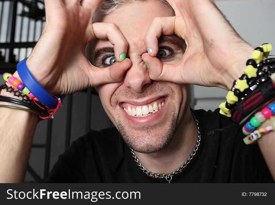 Man with his hands over his face in the shape of glasses. Man with his hands over his face in the shape of glasses