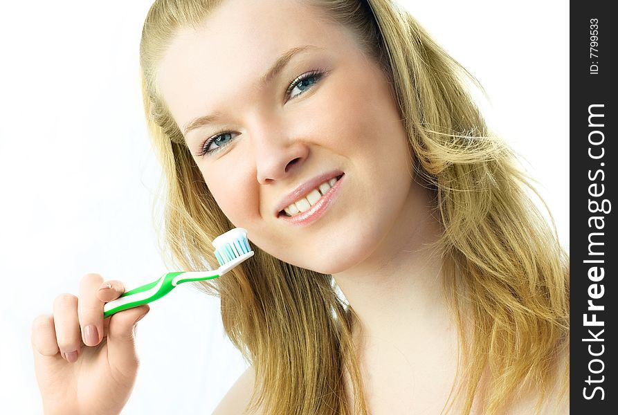 Portrait of a happy young blond woman brushing her teeth