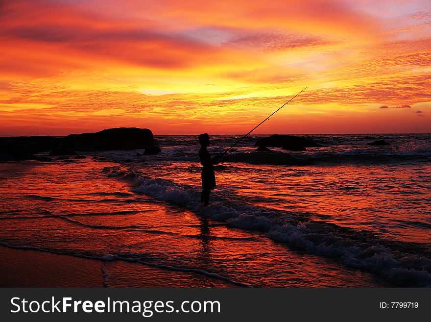 Man with fishing rod on coastline at sunset time. Man with fishing rod on coastline at sunset time