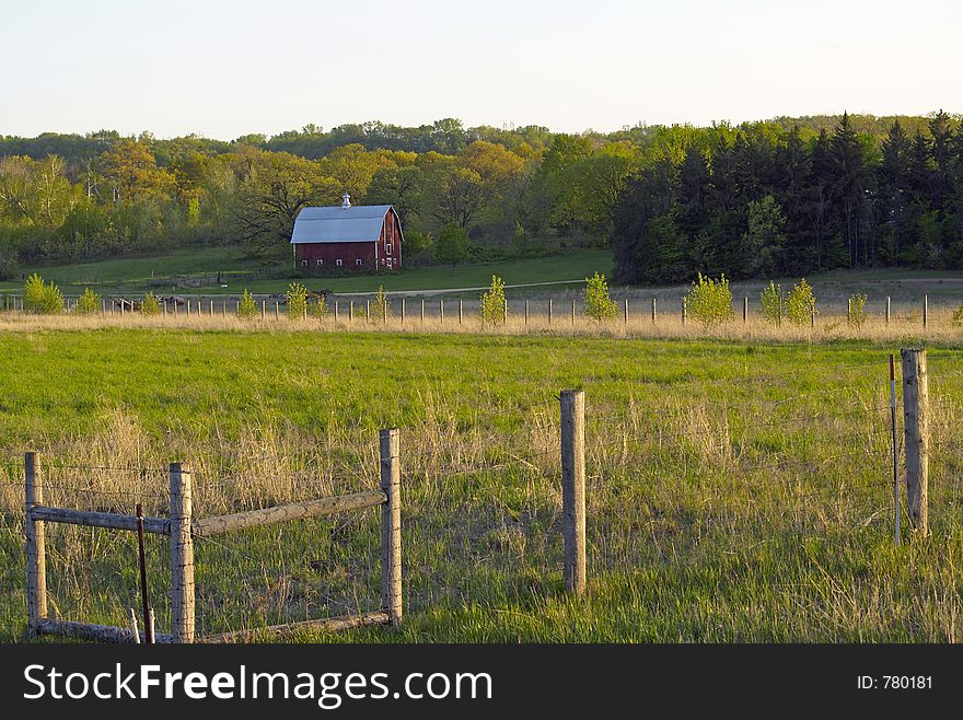 Fence with Red Barn and Farmland in Background