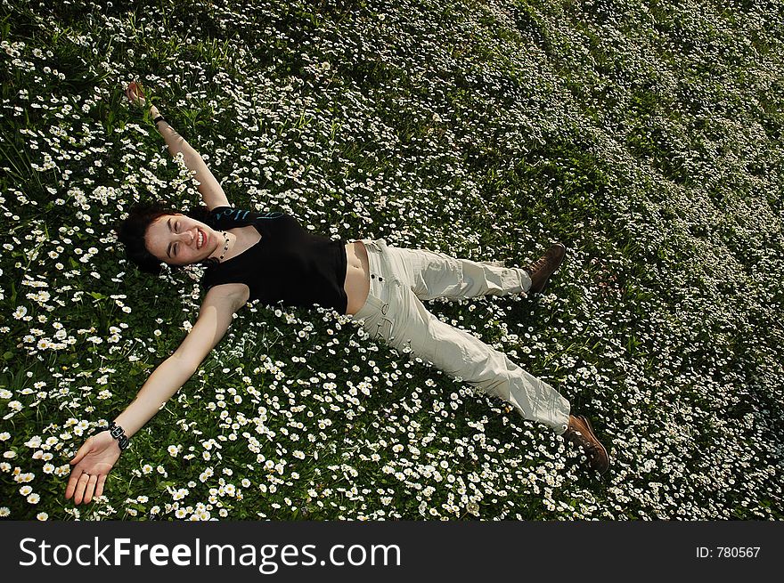 Girl in the flowers with a smile on her face. Girl in the flowers with a smile on her face