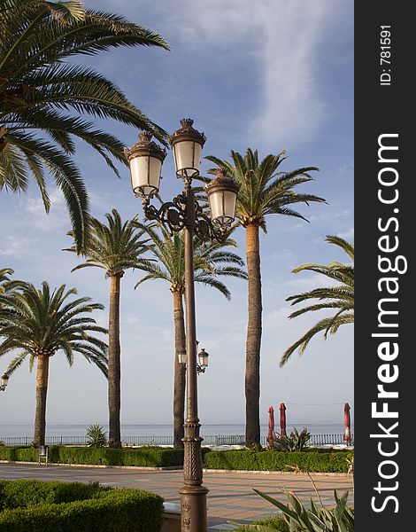 Iron lamp post and palm trees on the Balcon Europa, Nerja. Iron lamp post and palm trees on the Balcon Europa, Nerja