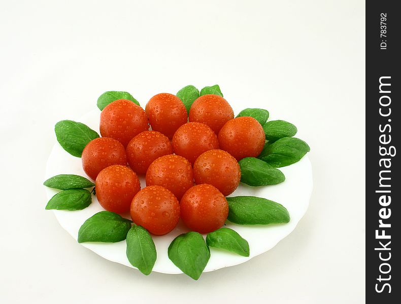 Some cherry tomatoes with dewdrops put together with fresh basil leaves. Some cherry tomatoes with dewdrops put together with fresh basil leaves