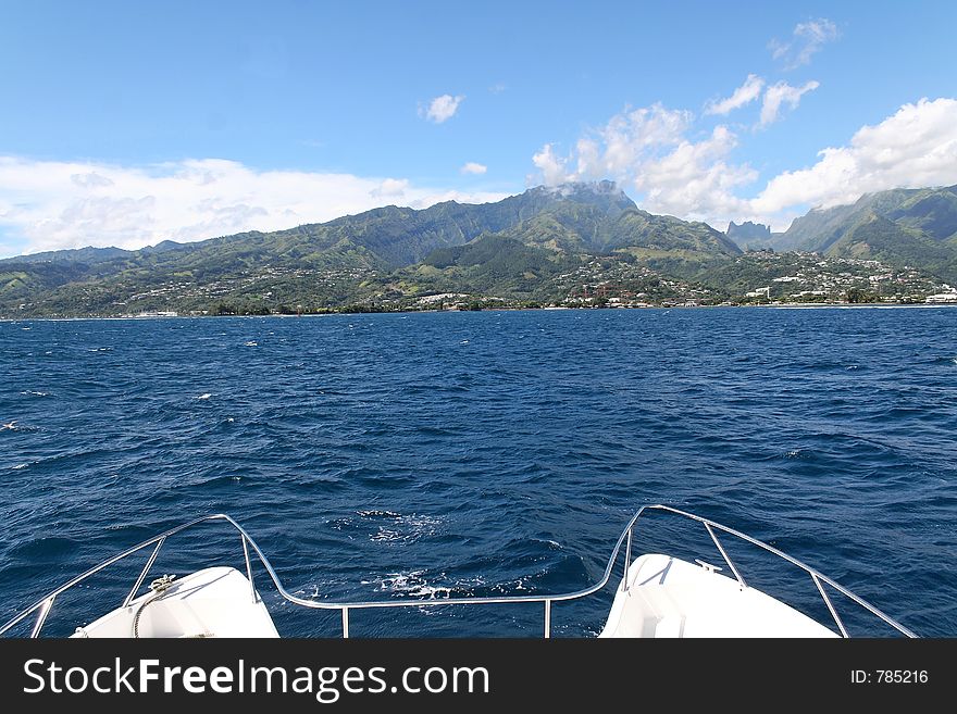 Catamaran boat facing the coastline on the pacific ocean. Catamaran boat facing the coastline on the pacific ocean