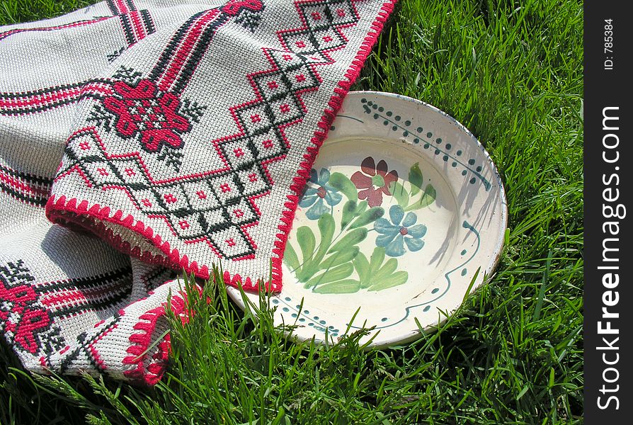 Decorative plate on grass covered by traditional table-cloth. Decorative plate on grass covered by traditional table-cloth