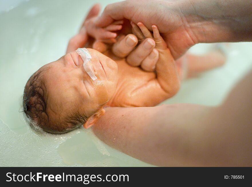 Premature baby boy having his first bath