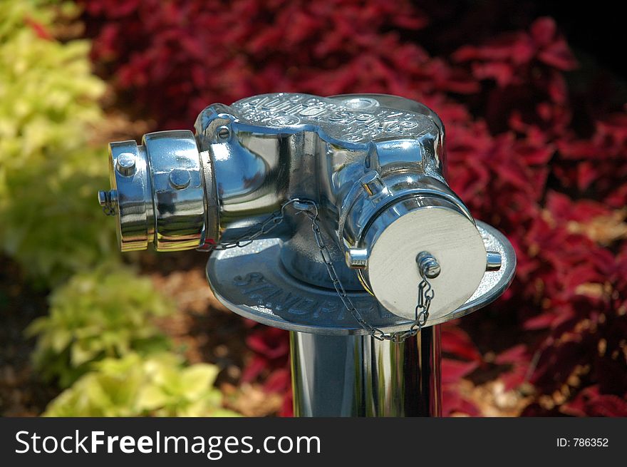 A chrome plated standpipe, against a green and purple background. A chrome plated standpipe, against a green and purple background.
