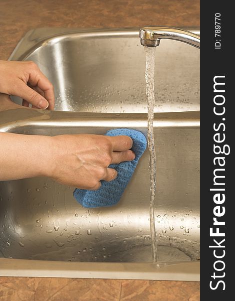Washing the sink with blue sponge