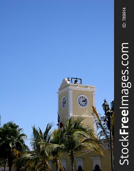 Yellow clock tower in church against blue sky. Yellow clock tower in church against blue sky