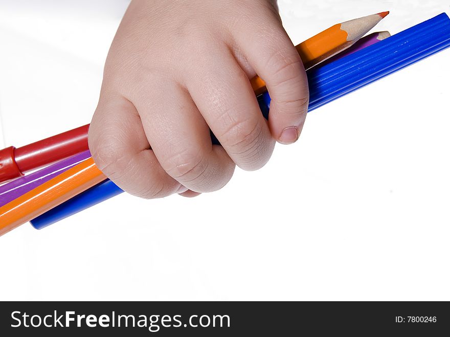 One boys hand holding a bunch of penns with a white background. One boys hand holding a bunch of penns with a white background.