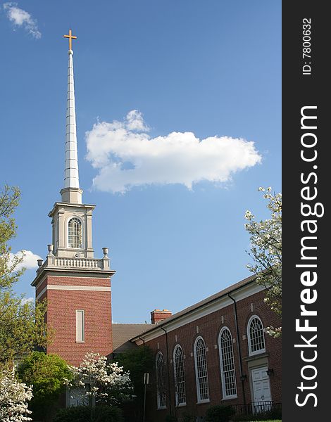 A traditional-style church steeple topped by a cross rises into a brilliant blue sky, with a few nice-day white clouds. Focus is on the steeple & cross. Please use respectfully. A traditional-style church steeple topped by a cross rises into a brilliant blue sky, with a few nice-day white clouds. Focus is on the steeple & cross. Please use respectfully.