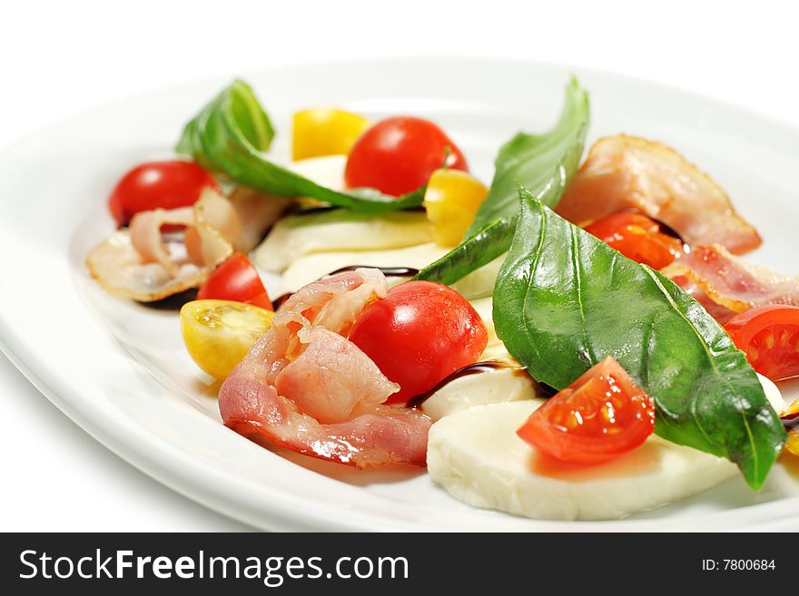 Salad with Cherry Tomato, Buffalo Cheese, Bacon and Vegetable Leaf. Isolated on White Background. Salad with Cherry Tomato, Buffalo Cheese, Bacon and Vegetable Leaf. Isolated on White Background