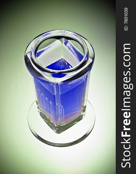 Laboratory glass beaker filled with a blue chemical solution, isolated, vignette.