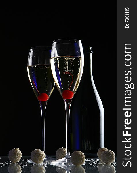 Two glasses with champagne and desert cherry