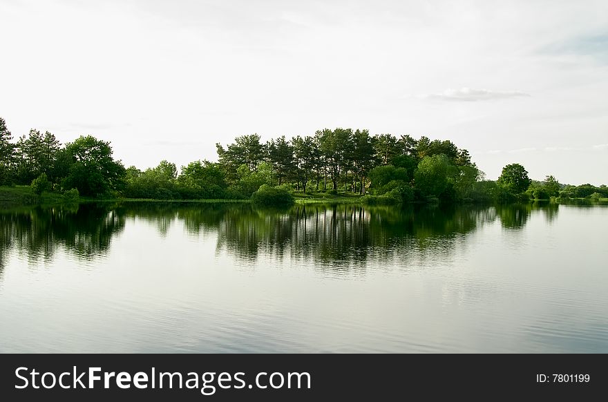 Picturesque landscape spring river and bright trees and bushes, against the backdrop of gray skies. Picturesque landscape spring river and bright trees and bushes, against the backdrop of gray skies.