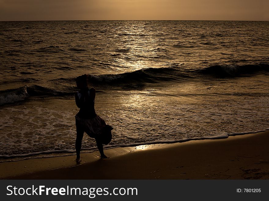 Silhouette of girl on sunset beach