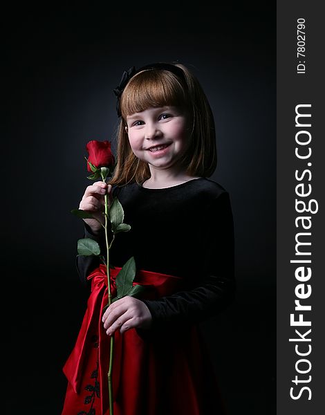 Pretty young girl holding long stemmed red rose. Pretty young girl holding long stemmed red rose