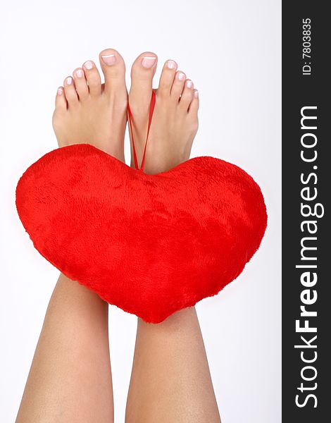 Woman legs with plush heart. Woman legs with plush heart