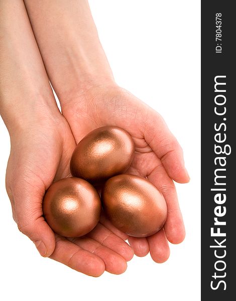 Female hands hold three gold Easter eggs on a white background. Female hands hold three gold Easter eggs on a white background