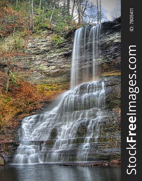 Beautiful tall waterfall falling into a lagoon during autumn. Beautiful tall waterfall falling into a lagoon during autumn.