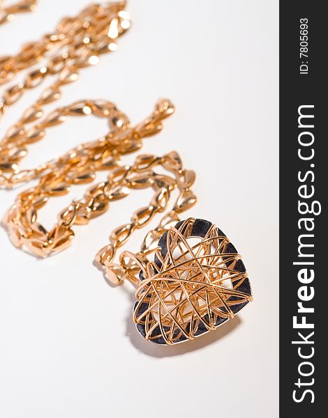 Gold pendant as a heart is on a chain. Gold pendant as a heart is on a chain