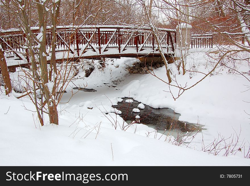 An image of a bridge with a frozen creek underneath. An image of a bridge with a frozen creek underneath.