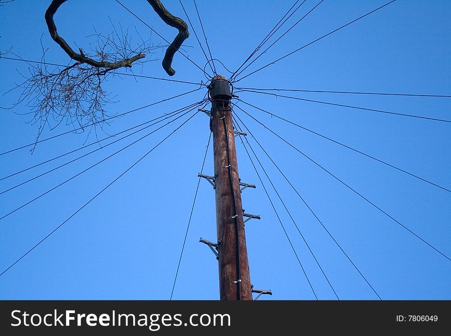 Telephone pole and lines against a blue sky