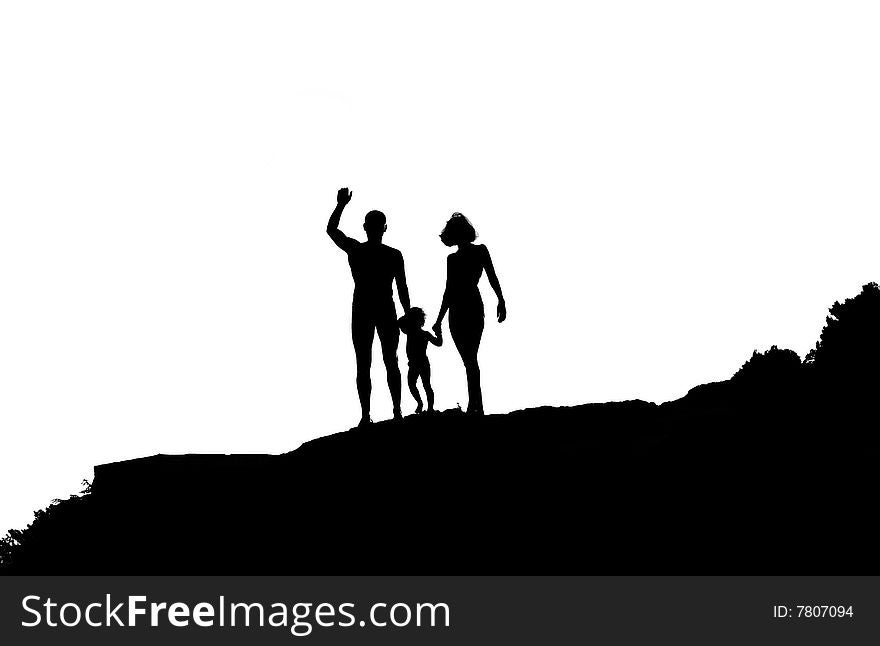 Silhouettes of three people. The man, the child and the woman stand on a hill