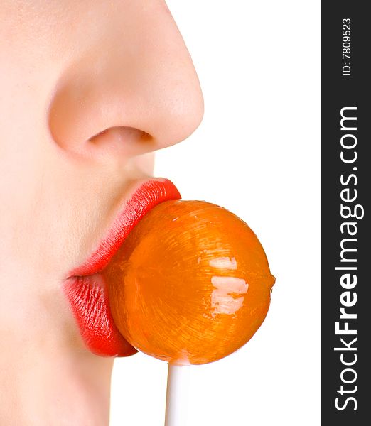 A woman with the brightly painted lips sucks a lollipop candy. Shallow DOF.