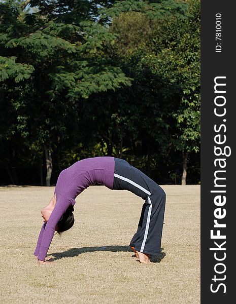 Young Asian Woman exercising Yoga in the park