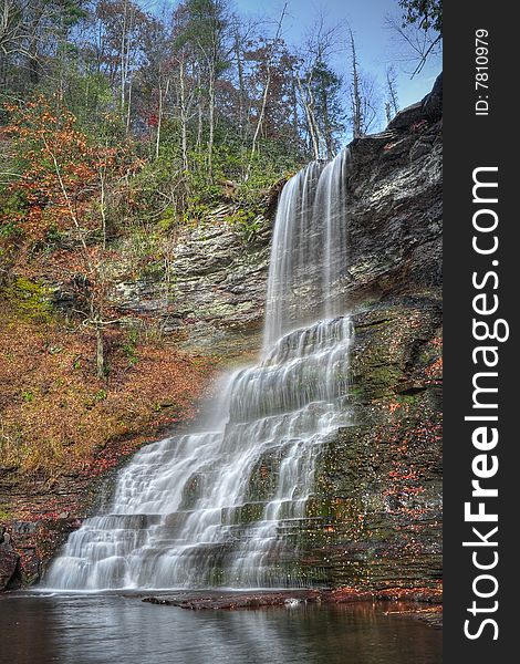 Beautiful tall waterfall falling into a lagoon during autumn. Beautiful tall waterfall falling into a lagoon during autumn.