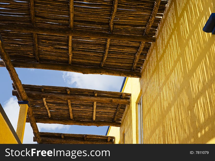 A wooden roof with a yellow wall in a Caribbean resort