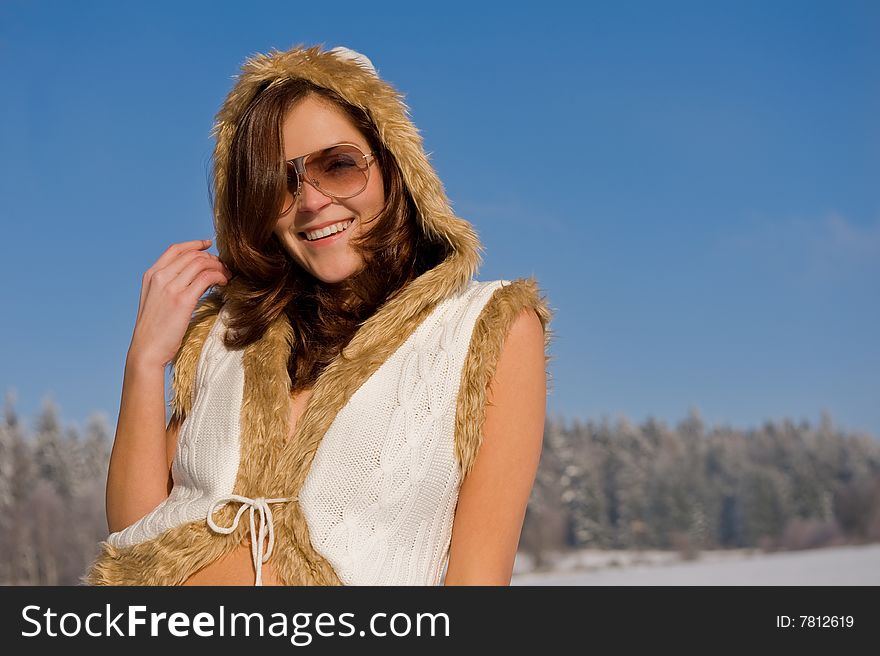 Smiling young woman with sunglasses in winter nature