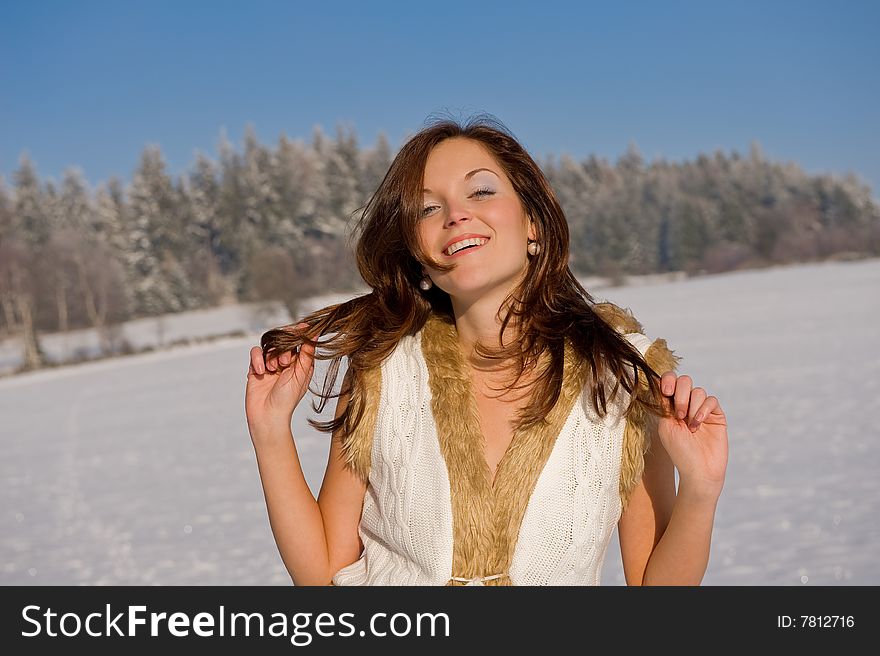 Sexy brunette woman in winter outfit on snow