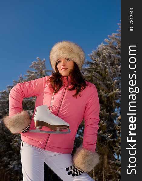 Sportive woman in pink jacket with ice skates