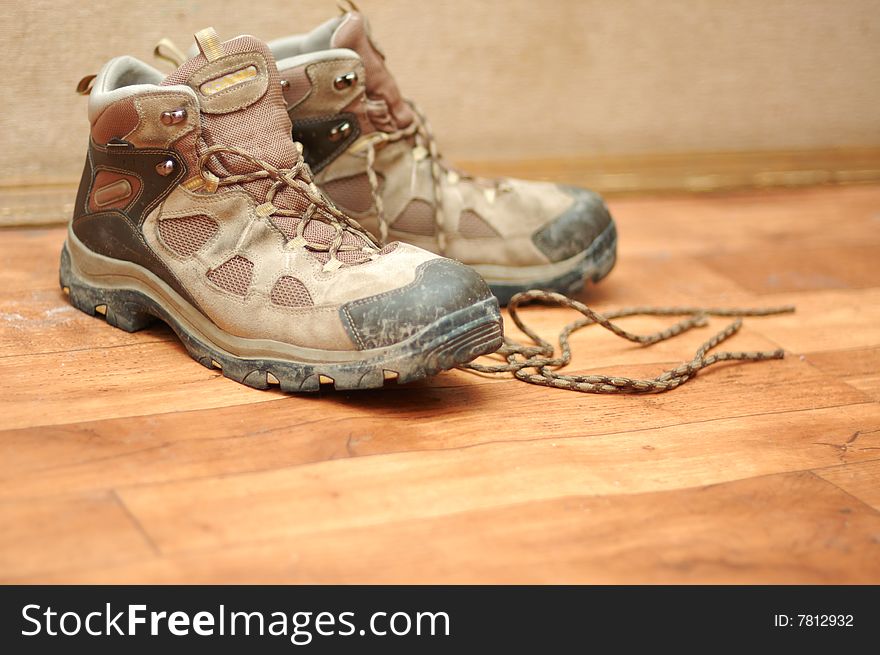 Old dirty man boots on wooden floor