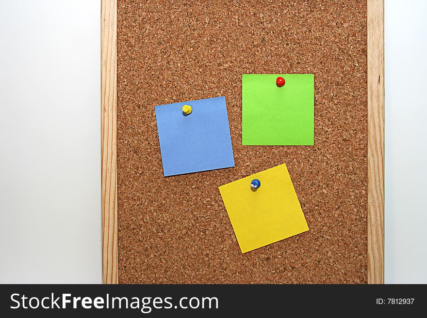 Cork board in white background, with colored notes. Cork board in white background, with colored notes